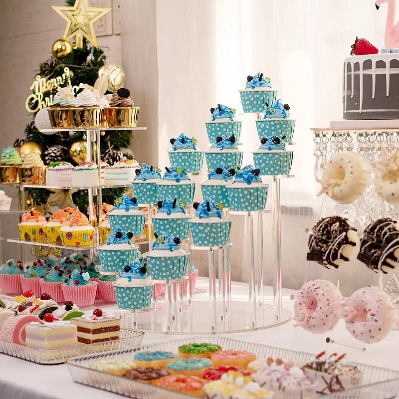 A tiered acrylic display rack holding numerous colorful cupcakes and desserts for an event.