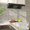 A kitchen setup featuring a Siemens range hood above a countertop with light gray subway tile backsplash and white cabinetry.