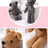 A close-up of a gray knitted stuffed bear key pendant and a light brown knitted bear detail.