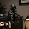 A detailed resin collectible statue of a tactical sniper soldier wearing a helmet and tactical gear.