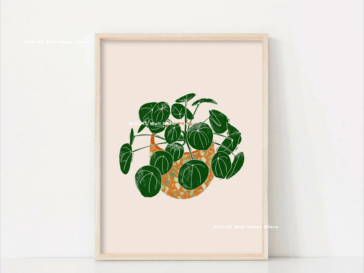 Botanical philodendron canvas wall art featuring a green plant in an orange pot framed in light wood.