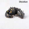 A dark obsidian dragon figurine with gold accents, used for Feng Shui decor.