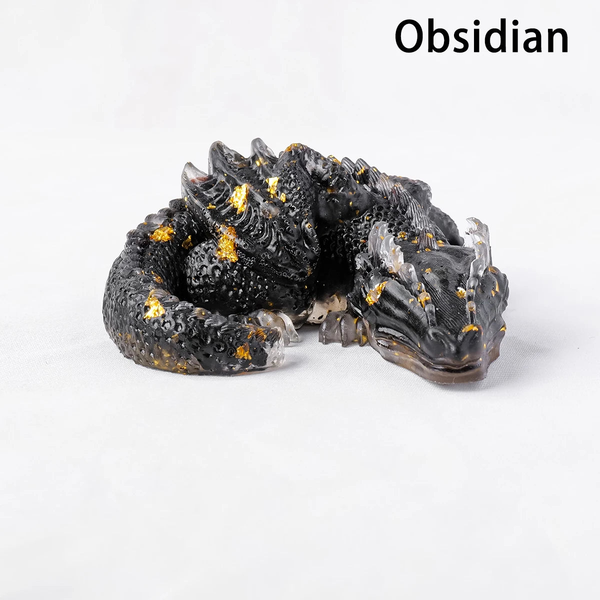 A dark obsidian dragon figurine with gold accents, used for Feng Shui decor.