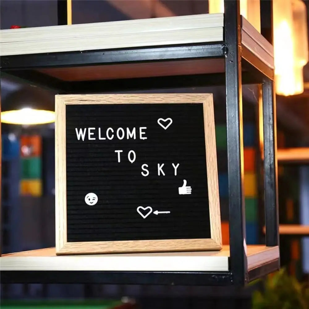 A wooden message board with white text and icons welcoming to sky inside a glass frame.