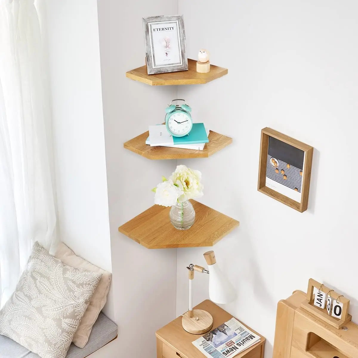 A set of two natural wood wall-mounted corner shelves displaying various decorative items like a framed picture, an hourglass