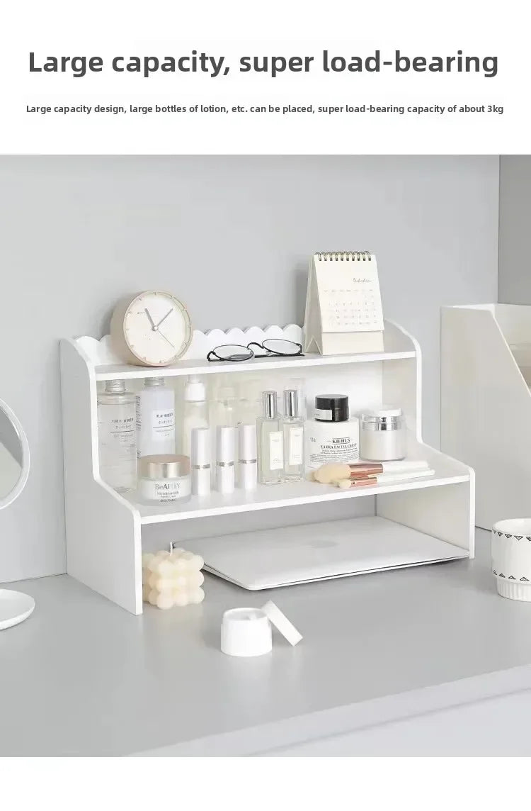 A white two-layer desktop organizer shelf displaying various small items like bottles, candles, and accessories.