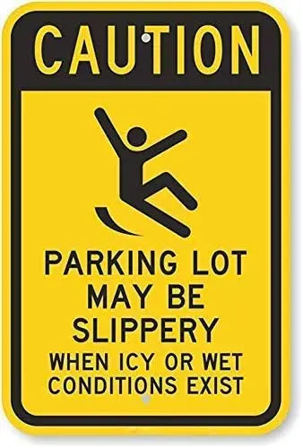 Yellow caution sign warning that a parking lot may be slippery in icy or wet conditions.
