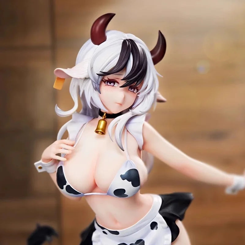A white cow-girl miniature figure with horns and a gold bell, wearing a black and white spotted outfit.
