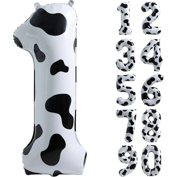 A white foil balloon shaped like the number one with black cow print spots.