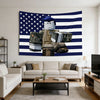 A wall tapestry featuring the American flag design with a stylized figure wearing a blue hat and holding binoculars.