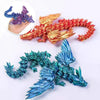 A set of three 3D printed magic dragon desktop ornaments in purple, orange, and teal colors.