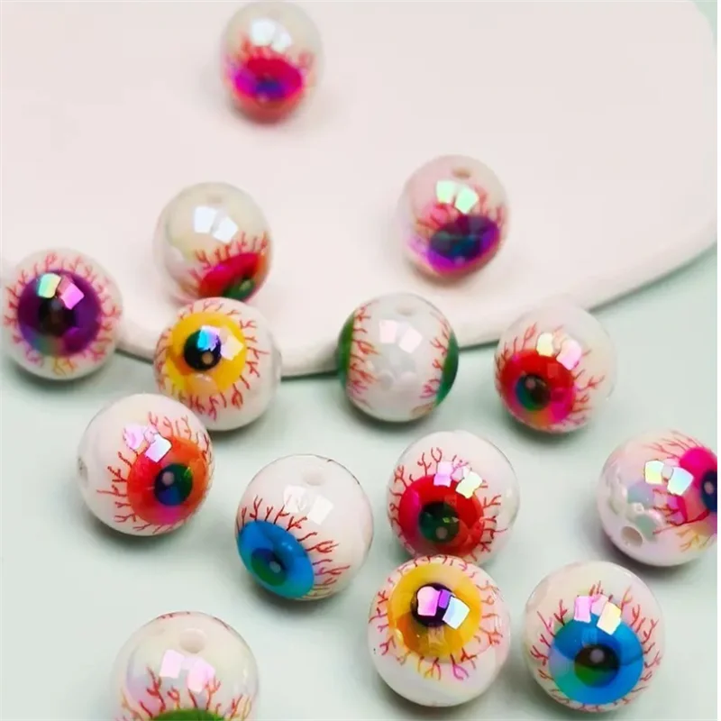 Un ensemble de dix perles de spasers oculaires en acrylique irisées avec des designs colorés et effrayants, éparpillées sur u