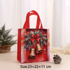 A red non-woven gift tote bag featuring a festive Christmas print with pine branches and bells.