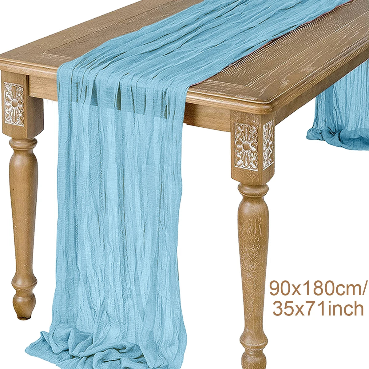 Light blue semi-sheer gauze table runner draped over a wooden table.