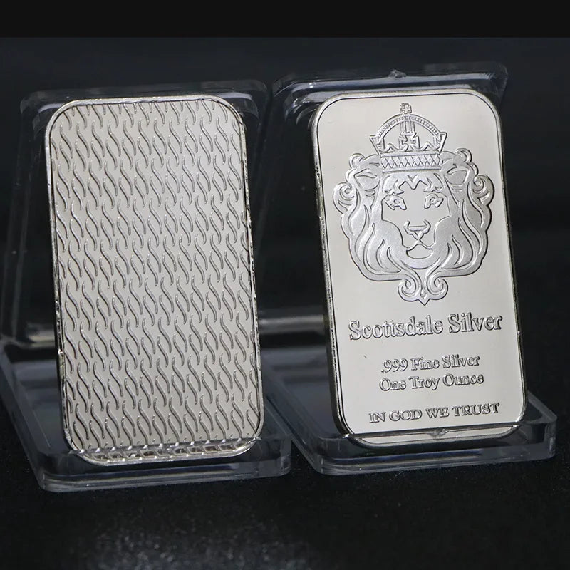 A silver bullion bar replica featuring a crown and lion design is displayed in protective plastic packaging.