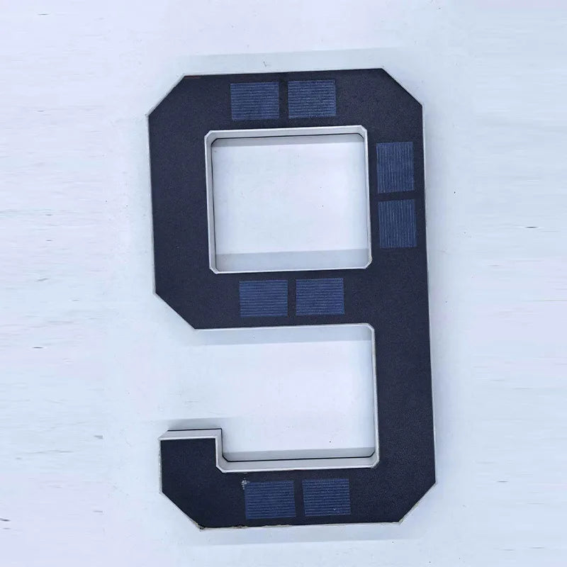 Señal de número de casa negra con forma de 9 y elementos de luz azul, para uso exterior.