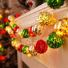 A string of festive gold and red LED fairy lights decorated with shiny spherical ornaments on a white mantelpiece.