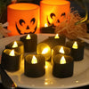 A plate of black LED candles with a warm white glow set against a dark background.