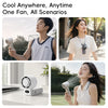A woman is using a foldable handheld fan to cool herself outdoors.