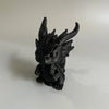 A black miniature dragon desk ornament with spiky horns and detailed texture.