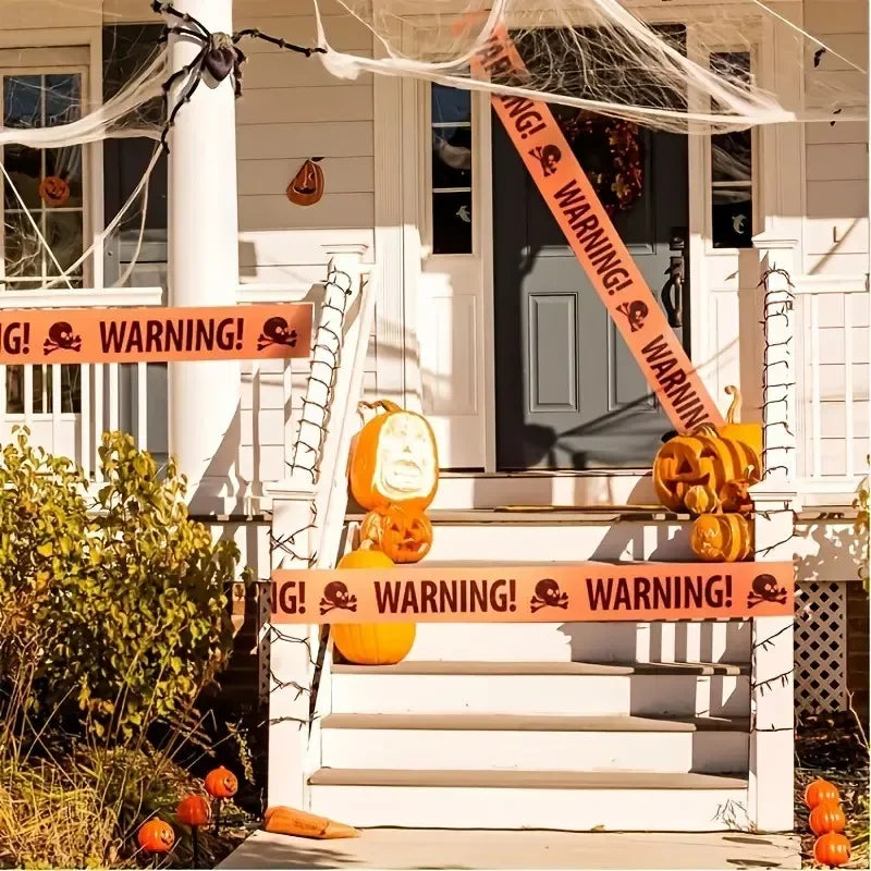 Halloween caution tape with spooky warning signs decorating a white porch and steps.