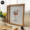 A wooden photo frame featuring a watercolor illustration of a flamingo on a white background.