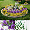 A close-up view of five artificial purple pansy flowers with green stems and leaves.