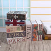 A stack of decorative wooden lock boxes featuring various city names and symbols like Love and Italy
