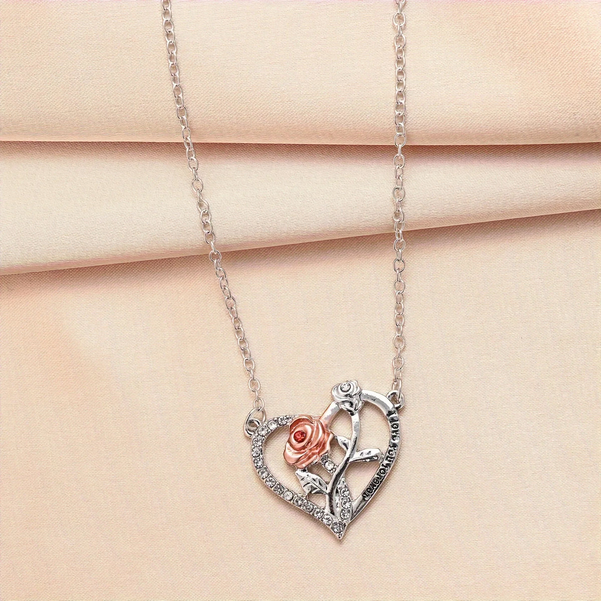 Silver pendant necklace featuring a rose and bear design on a delicate chain.