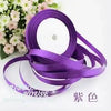 Purple silk satin ribbon rolls and loops on a white background
