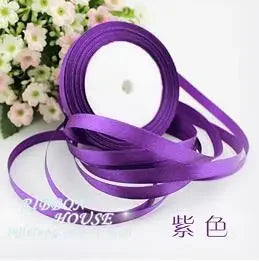 Purple silk satin ribbon rolls and loops on a white background