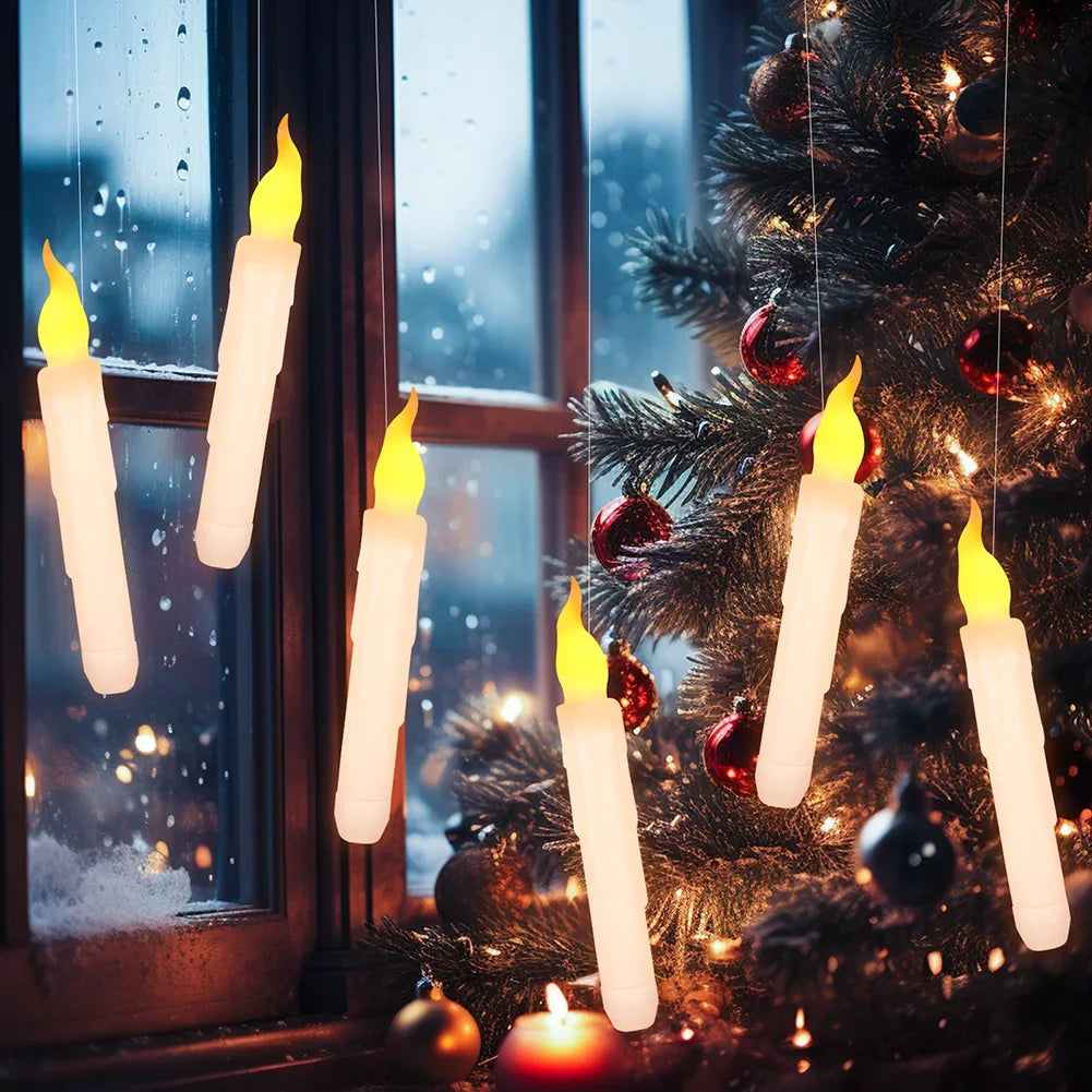 A close-up of glowing white LED floating candles hanging on a Christmas tree branch near a window.