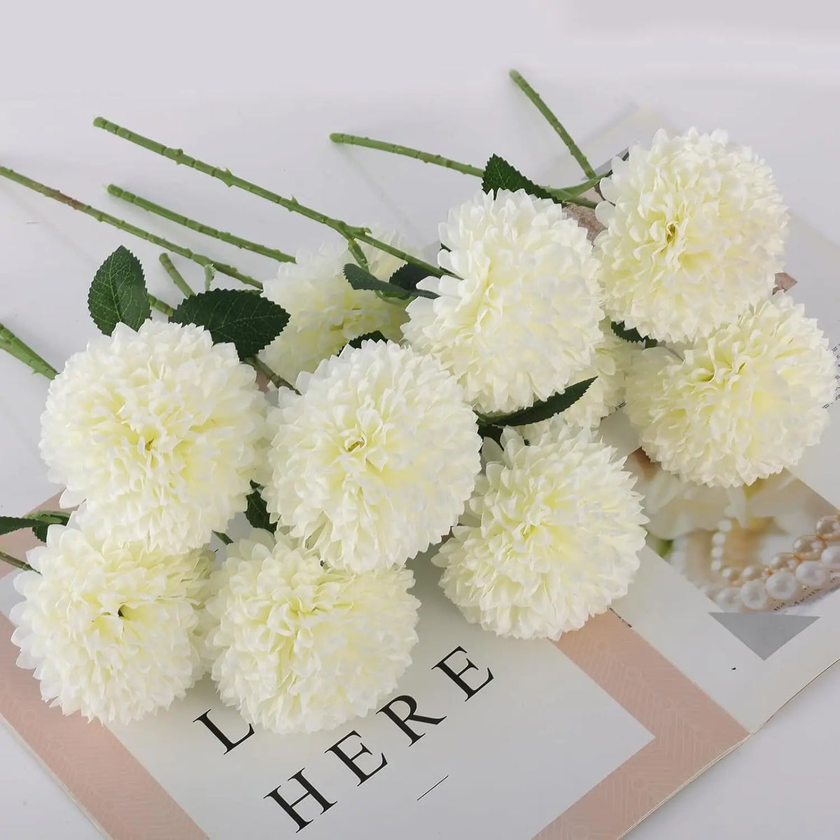 A cluster of fluffy white artificial chrysanthemum flower balls used for weddings and home decor.