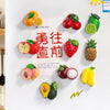 A display of colorful fruit magnets featuring apples, strawberries, pineapples, and citrus fruits on a white background.
