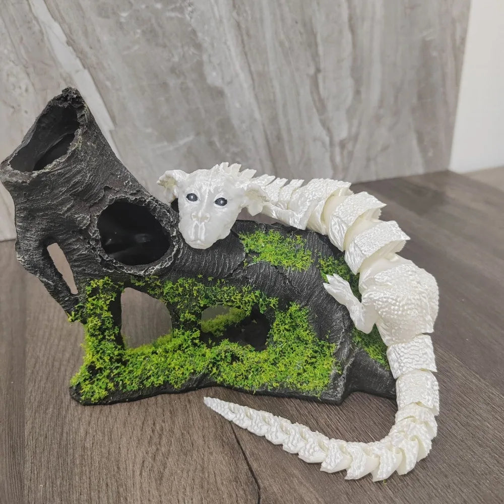 Figurine de dragon peinte à la main, sculptée dans une pierre sombre avec mousse verte et un élément serpentine blanc.