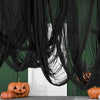 Black creepy gauze cloth draped in a window for Halloween decor