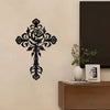 Black metal rose cross wall decor mounted on a beige wall above a wooden cabinet.