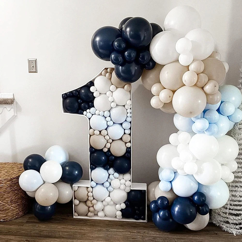 A large number one balloon arrangement featuring assorted latex balloons in shades of white, gray, and navy blue.