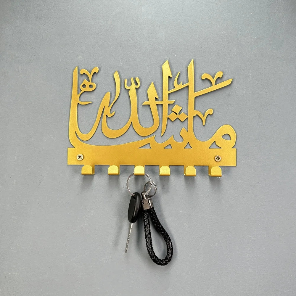 Gold Islamic Arabic blessing key holder with hooks mounted on a gray surface
