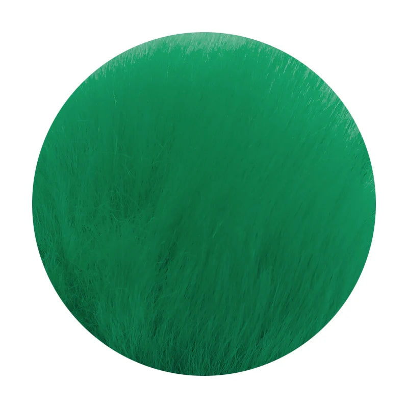A round pom pom keychain made of green faux fur attached to a silver chain.