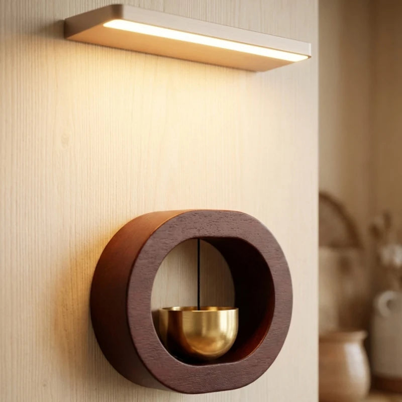 A modern wooden doorbell featuring a magnetic design and a brass wind chime.
