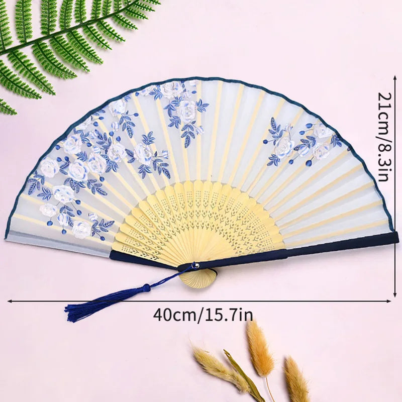 Elegant bamboo folding fan with blue and white floral patterns and a dark blue tassel