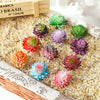 A collection of colorful mini artificial succulent bonsai balls in various shades of green, pink, and purple scattered on a l