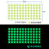 A grid of green glow-in-the-dark stars used as wall stickers, showing a bright green light against a dark background.