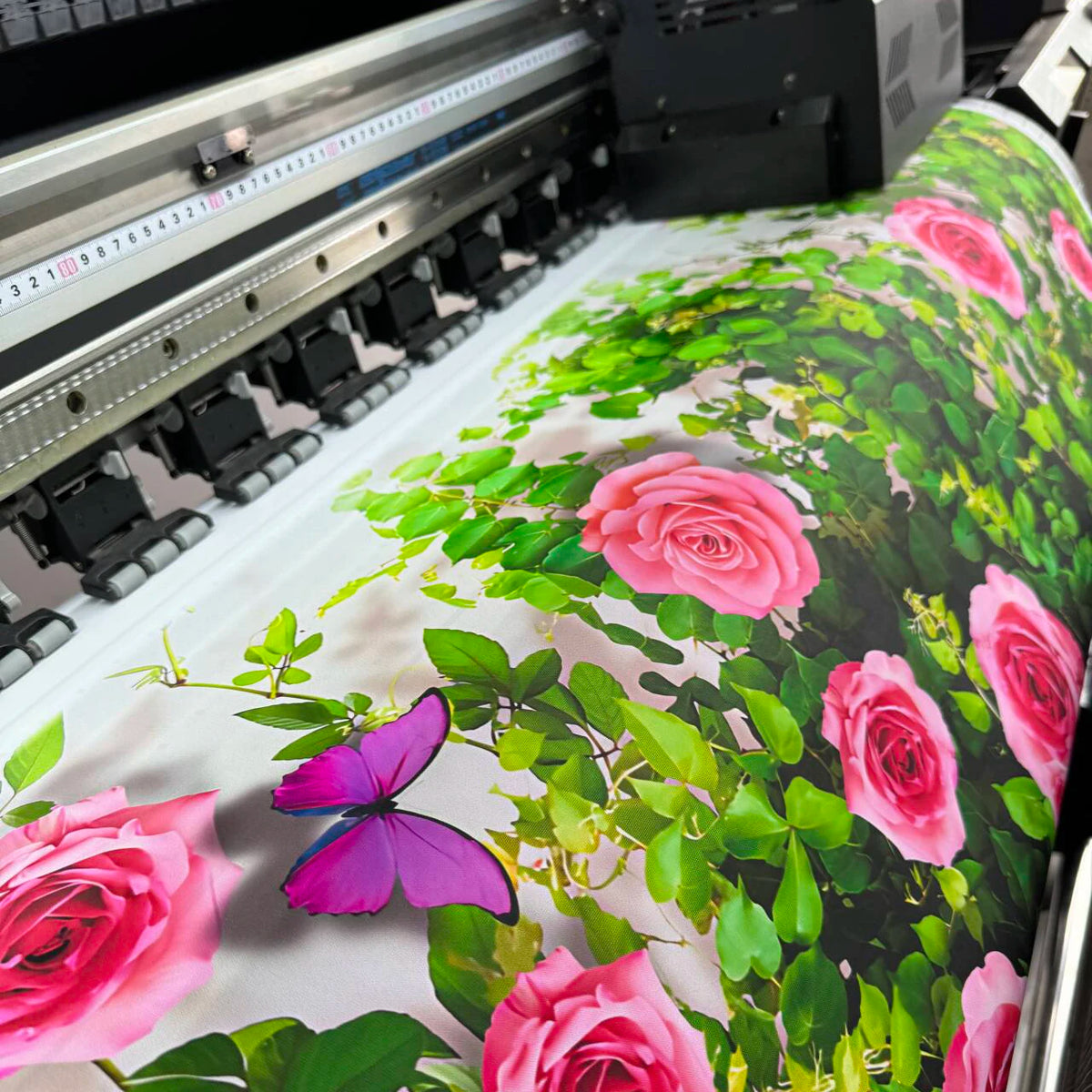 A floral backdrop featuring pink and magenta roses and green foliage for a soccer field party celebration.