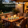 A set of six cute resin frog figurines displayed on a wooden table in an outdoor relaxation setting.