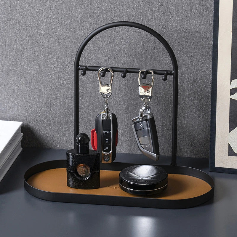 A black leather and wrought iron desk organizer rack holding two black pens.