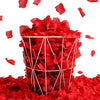Un panier de fil transparent rempli de pétales de roses artificielles rouges