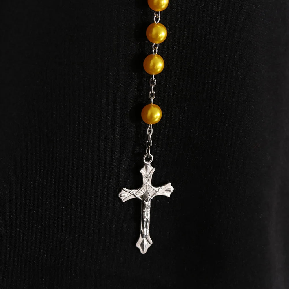A gold and silver rosary necklace featuring round beads and a vintage cross pendant.