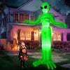 A 9ft tall green alien inflatable decoration with LED lights standing in a suburban yard at night.